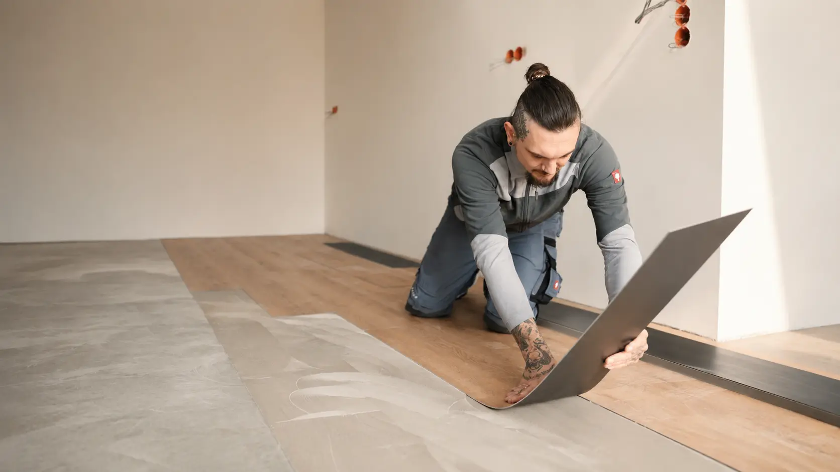 Bodenleger verlegt eine dunkelgraue Designboden- oder Vinylplanke