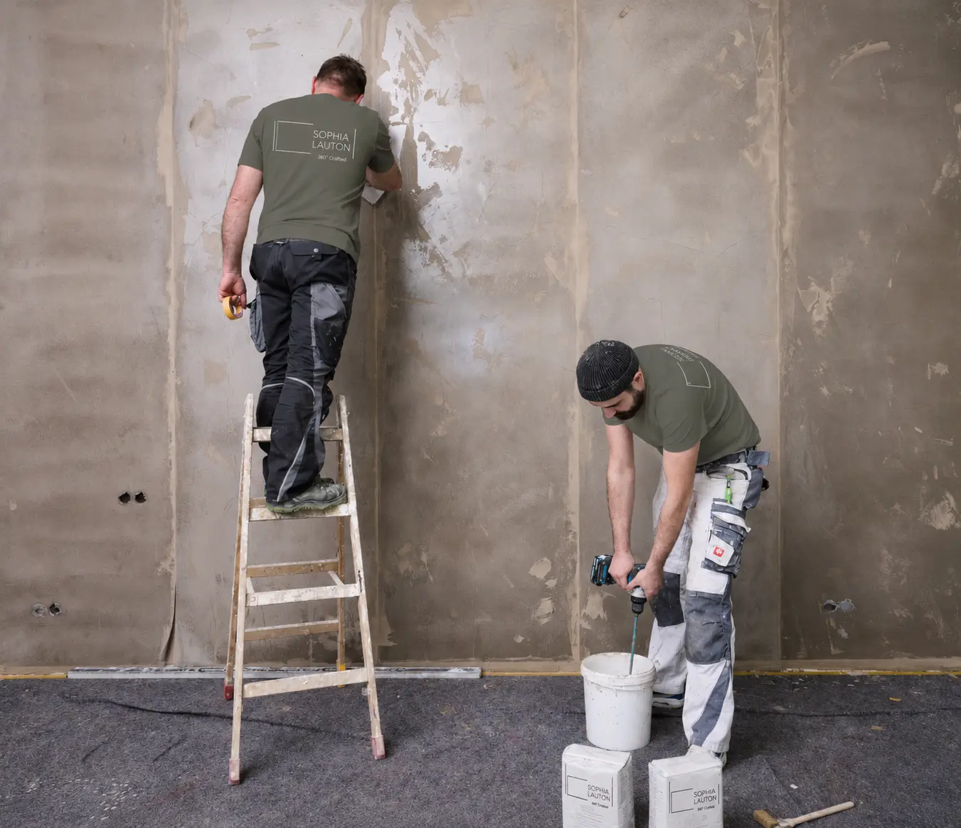 Zwei Handwerker beim Vorbereiten und Spachteln einer Innenwand