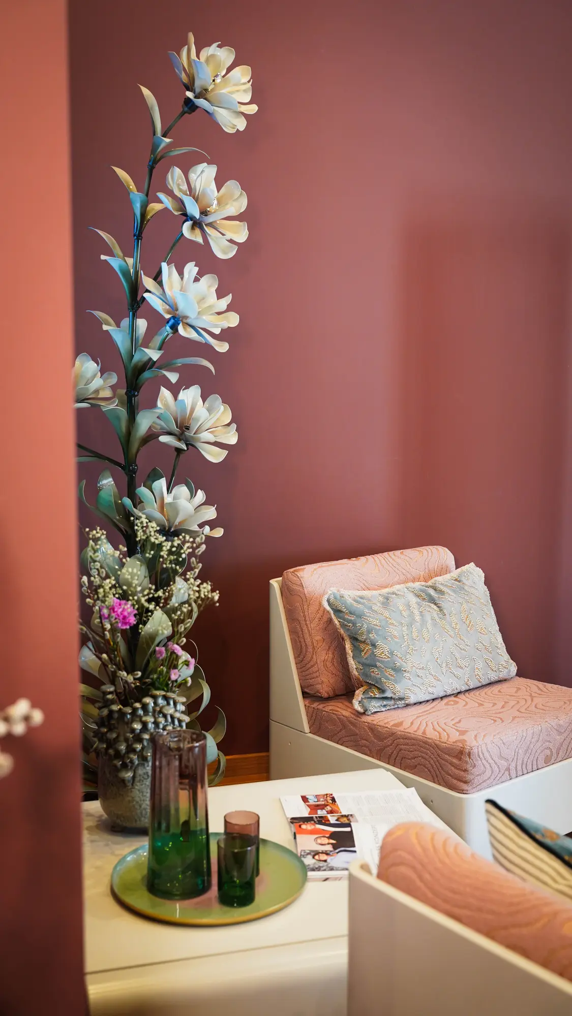 Korallrote Wand mit gepolstertem Sessel, Kissen und Dekoration